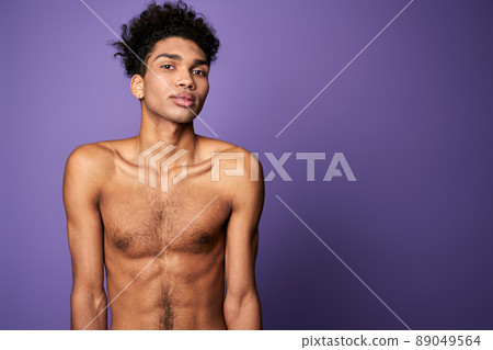 Portrait of latin american transgender model on purple background. Handsome young man posing camera 89049564