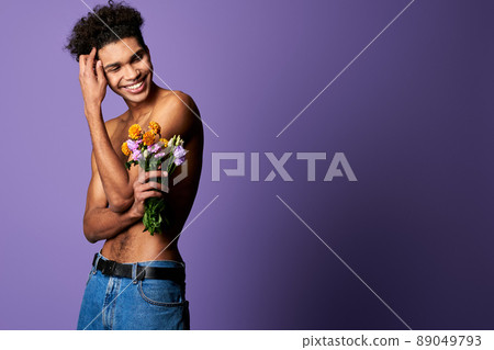 Portrait of smiling transgender male with flowers. Sensitive athletic sportsman with perfect body Portrait of smiling transgender male with flowers. Sensitive athletic sportsman with perfect body 89049793