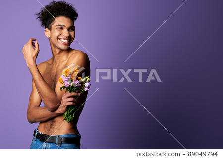 Smiling muscular transgender model with bouquet portrait. Nude torso young man of trans gender Smiling muscular transgender model with bouquet portrait. Nude torso young man of trans gender 89049794