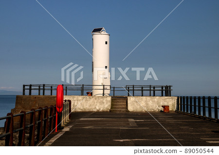 Harbour Light at the End of a Coastal Jetty 89050544