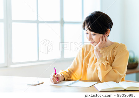 Middle woman studying in the living room Middle woman studying in the living room 89050993