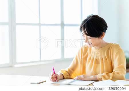 Middle woman studying in the living room Middle woman studying in the living room 89050994