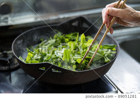 Senior woman steaming tea leaves in a pot Senior woman steaming tea leaves in a pot 89051281