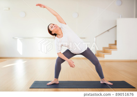 Pregnant woman is engaged in yoga. Extended Side Angle Pose or Utthita Parsvakonasana Pregnant woman is engaged in yoga. Extended Side Angle Pose or Utthita Parsvakonasana 89051676