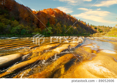 View of the waterfall in autumn. Waterfall in autumn colors. Mountain river in the autumn landscape. Ukraine, river Stryj. 89052606