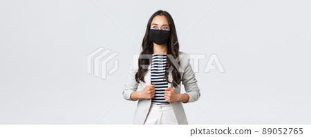 Business, finance and employment, covid-19 preventing virus and social distancing concept. Stylish elegant female entrepreneur in mask against coronavirus, having meeting, looking up confident 89052765