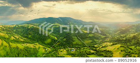 Aerial view of the endless lush pastures of the Carpathian expanses and agricultural land. Cultivated agricultural field. Rural mountain landscape at sunset. Ukraine. 89052916