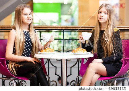 Happy friends toasting cappuccino at bar cafeteria - Young trendy people enjoying breakfast eating drinking coffee. Friendship and morning break concept. 89053185