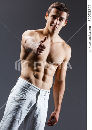 pain relief, sport, bodybuilding, strength and people concept - young man standing over black background 89053205