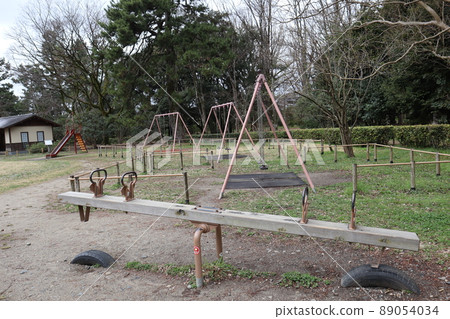 Seesaw, swing, slide, resting hut and park scenery with various trees and plants Seesaw, swing, slide, resting hut and park scenery with various trees and plants 89054034