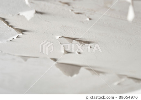 Peeling paint in plaster ceiling of bathroom and toilet. Moisture and humidity in room. Close up 89054970