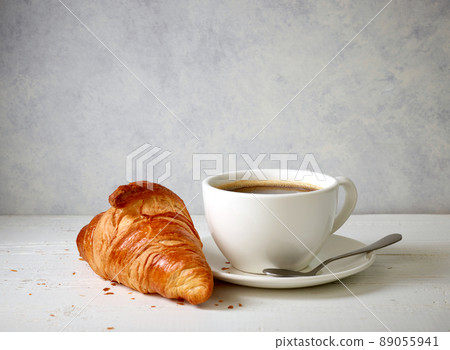 freshly baked croissant and cup of coffee freshly baked croissant and cup of coffee 89055941