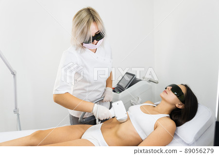 Woman in white underwear doing laser hair removal in a beauty salon 89056279
