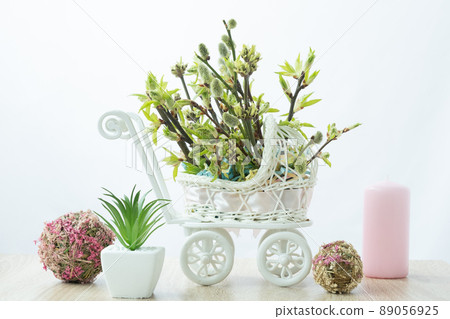 Home decoration. Branches of different trees grow from a toy stroller. Stylish and unusual decor for Easter. Jewelry with a hint of pregnancy. Mothers Day 89056925