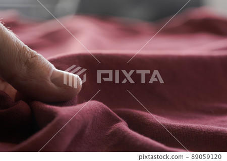 man hand touching red wine color cotton fabric man hand touching red wine color cotton fabric 89059120