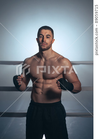 Boxer, man posing in bandage on boxing ring. Fitness and boxing concept.  89059715