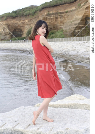 A young woman in a one-piece swimsuit posing against the backdrop of Byobugaura 89059810