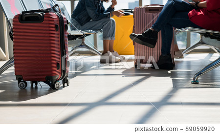 Carry on suticase and passengers at waiting seat in airport Carry on suticase and passengers at waiting seat in airport 89059920