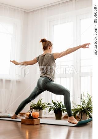 Beautiful young woman doing exercises and doing yoga at home Beautiful young woman doing exercises and doing yoga at home 89060697