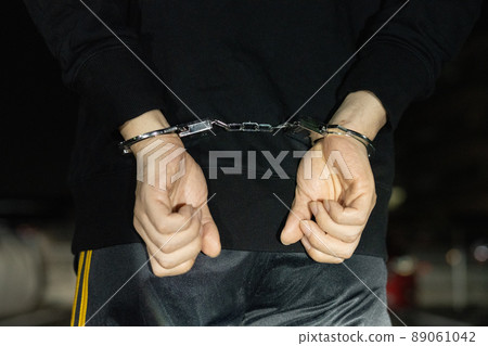 The arm of a man who is handcuffed in the back The arm of a man who is handcuffed in the back 89061042