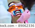 Woman patient with protective glasses for teeth whitening procedure. 89062336