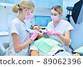 Orthodontist and assistant scaning patient's teeth with intraoral 3d scanner 89062396