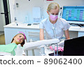 Dentist and patient looking at dental scan on laptop screen. 89062400
