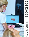 Dentist and patient are watching result of a 3D scan on a laptop screen 89062402