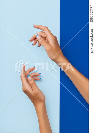 Beautiful womans hands trendy nail design on blue background 89062774