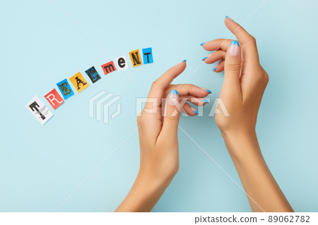 Manicured womans hands with inscription treatment on blue Manicured womans hands with inscription treatment on blue 89062782