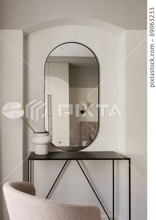 Single white Anthurium flower in ceramic vase on metal black console table in bedroom interior. Modern interior decoration concept. 89063233