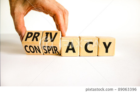Privacy or conspiracy symbol. Businessman turns the wooden cube and changes the word Conspiracy to Privacy. Beautiful white table white background. Business privacy and conspiracy concept. Copy space. Privacy or conspiracy symbol. Businessman turns the wooden cube and changes the word Conspiracy to Privacy. Beautiful white table white background. Business privacy and conspiracy concept. Copy space. 89063396
