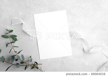 Wedding stationery invitation cards mockup 5x7 on neutral grey stone background with eucalyptus leaves 89064038