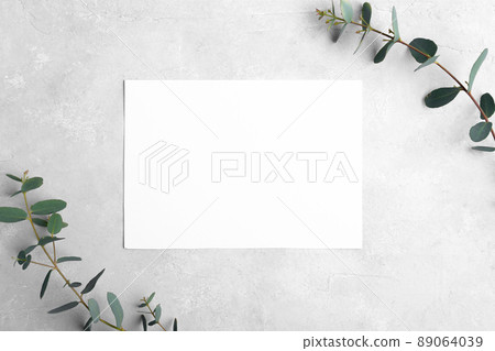 Wedding stationery landscape invitation card mockup 5x7 on neutral grey stone background with eucalyptus leaves 89064039