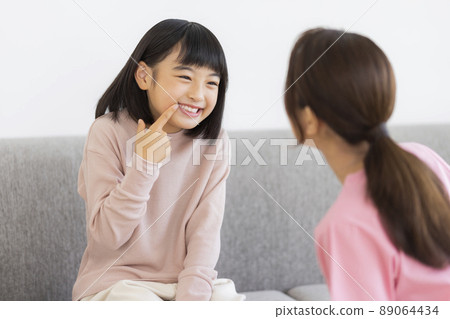 女孩兒科牙科向牙科工作人員展示牙齒 女孩兒科牙科向牙科工作人員展示牙齒 89064434