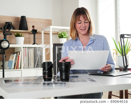 Female photographer working at office studio Female photographer working at office studio 89064616