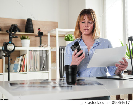 Female photographer working at office studio 89064617