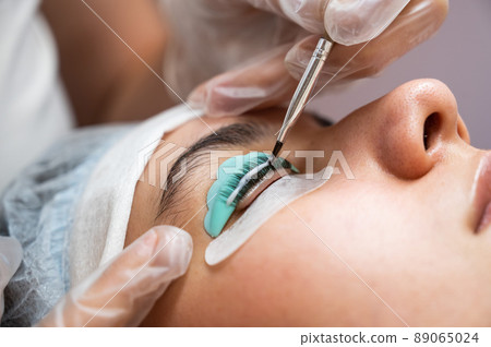 Close-up portrait of a woman on eyelash lamination procedure.  89065024