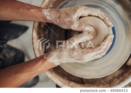 Top Down View of Potter Master at Work in Clay Studio, Handmade Process of Creating Pot on a Pottery Wheel Top Down View of Potter Master at Work in Clay Studio, Handmade Process of Creating Pot on a Pottery Wheel 89066415