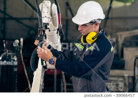 Young factory worker working with adept robotic arm 89066457