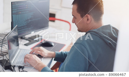 A man in a turquoise sweater in a bright office while working at a computer close-up. Work illustration A man in a turquoise sweater in a bright office while working at a computer close-up. Work illustration 89066467