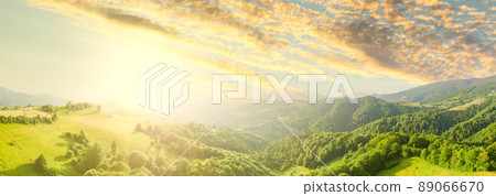 Aerial view of the endless lush pastures of the Carpathian expanses and agricultural land. Cultivated agricultural field. Rural mountain landscape at sunset. Ukraine. Aerial view of the endless lush pastures of the Carpathian expanses and agricultural land. Cultivated agricultural field. Rural mountain landscape at sunset. Ukraine. 89066670