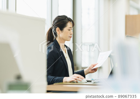 Middle woman working in the office Middle woman working in the office 89067335