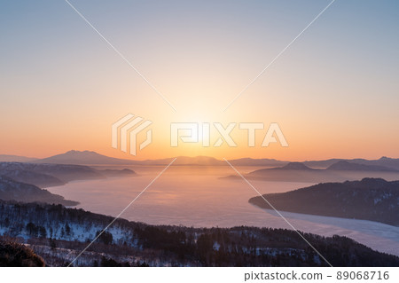 The sun rises on Lake Kussharo as seen from Bihoro Pass 89068716