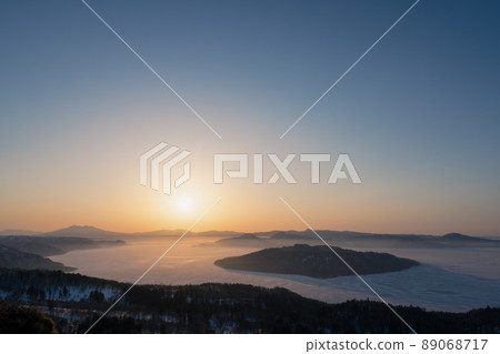 The sun rises on Lake Kussharo as seen from Bihoro Pass 89068717