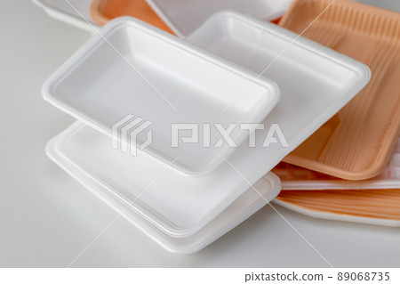 Lots of plastic trays on a white table Lots of plastic trays on a white table 89068735