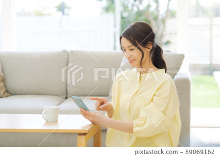 Woman holding a smartphone 89069162