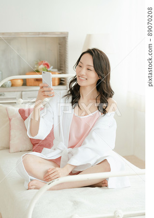 Young woman laughing at her smartphone 89070208