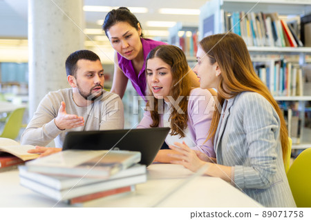 Group of students learning together at library Group of students learning together at library 89071758