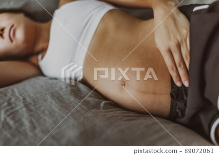 Pregnant woman lying in bed sad of depression or having or sleep problem. Closeup of belly skin with dark line from pregnancy symptom Pregnant woman lying in bed sad of depression or having or sleep problem. Closeup of belly skin with dark line from pregnancy symptom 89072061